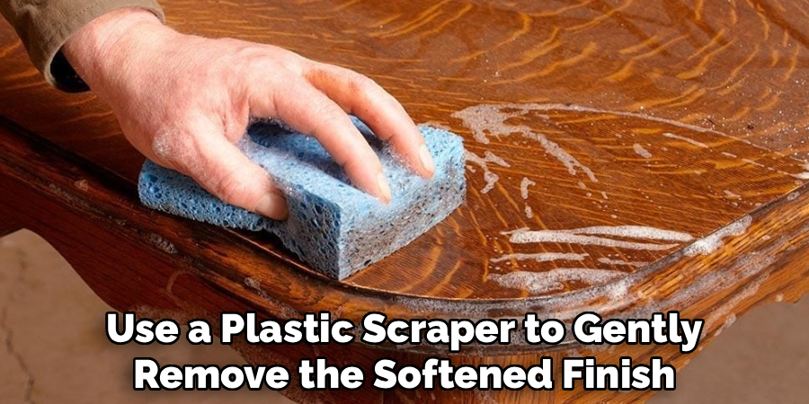 Use a Plastic Scraper to Gently Remove the Softened Finish